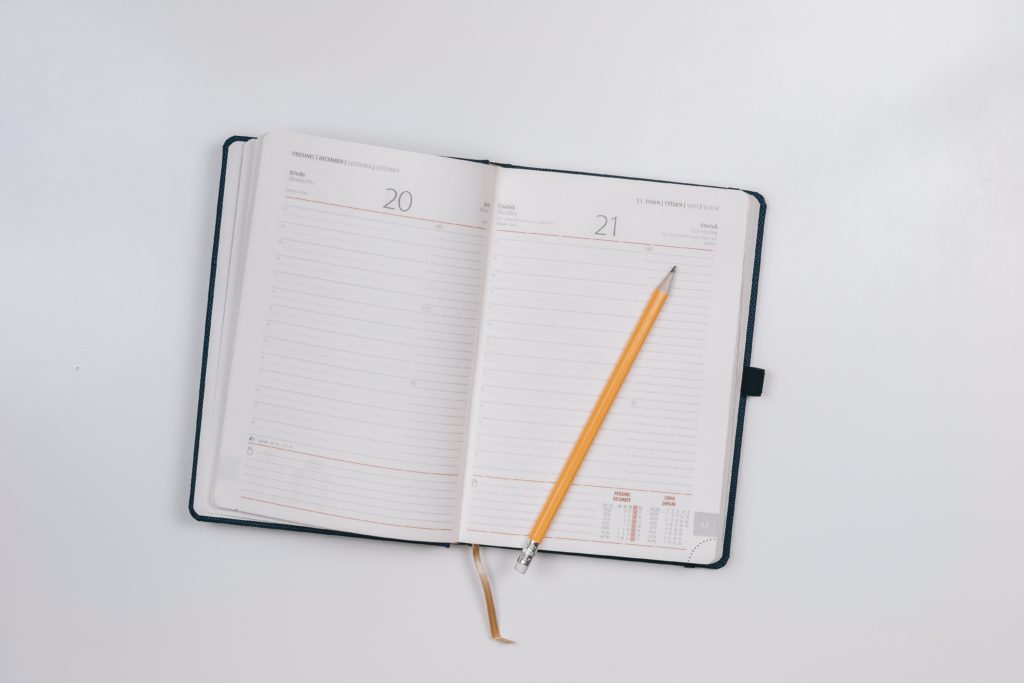 Open and empty planner with pen laying on top