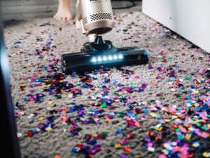 vacuum cleaner cleaning a carpet full of confetti